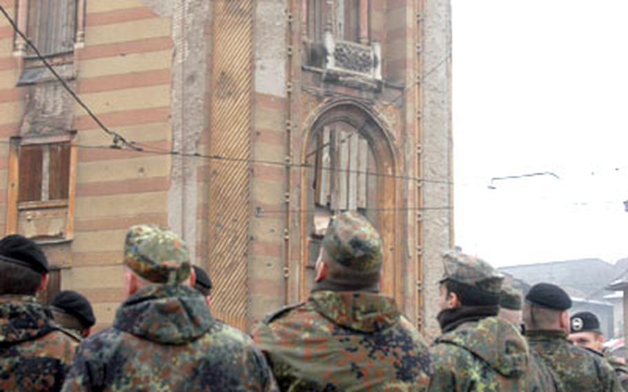 German soldiers touring Sarajevo take in the view of the National Library. An effort is currently under way to renovate the landmark, which was damaged in the war.