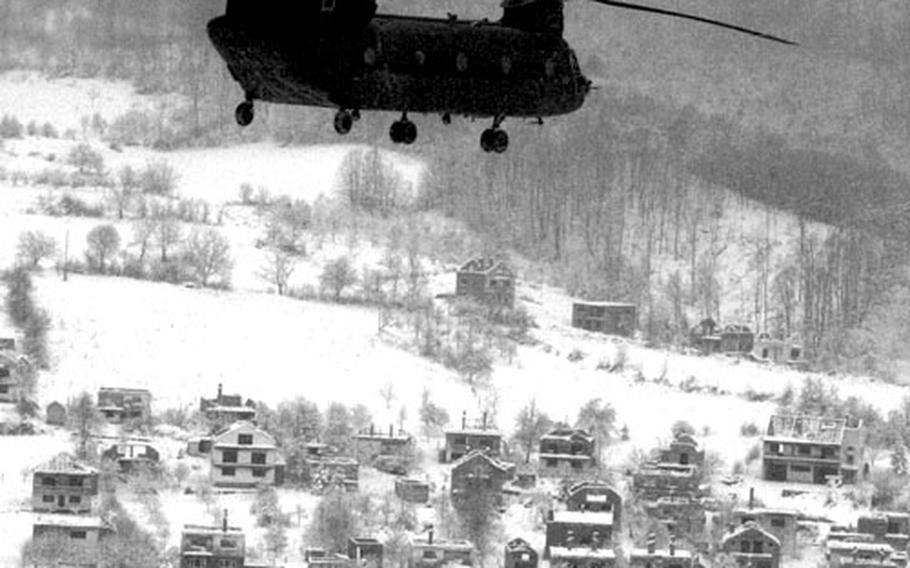 A Chinook of the 159th Aviation Regt. flies over a destroyed village in Bosnia early in the IFOR mission. The scars of war were a familiar sight for IFOR soldiers in Bosnia.