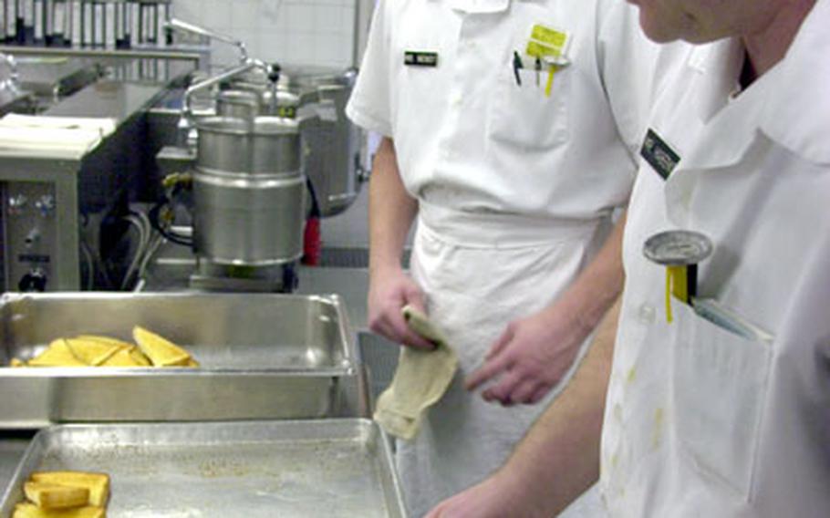 Camp Normandy Dining Facility Workers Maik Wenddt, left, and Thomas Haberkorn prepare garlic toast for lunch on Wednesday.