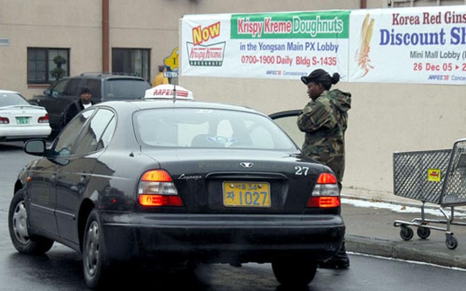 A soldier gets into an AAFES taxi cab outside the Post Exchange store on Yongsan Garrison. One suggestion from the family planning meeting for Area II was to ask AAFES to use zoned fares for on-base and off-base rides. AAFES officials said they cannot charge fees based on zones; the South Korean government requires taxis to run on meters.
