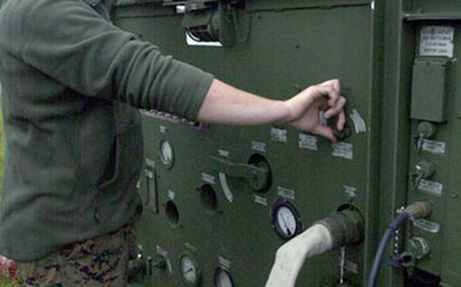 Lance Cpl. James T. Gann, a hygiene equipment operator with MEU Service Support Group 31, operates a Reverse Osmosis Water Purification Unit on Camp Hansen’s Kin Blue beach Thursday, converting saltwater to drinking water.
