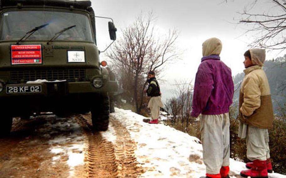 Disaster Relief Team Pakistani earthquake victims watch as NATO trucks deliver aid to refugees in the Kashmir region. NATO engineers are hard at work building shelters as frigid winter sets in.