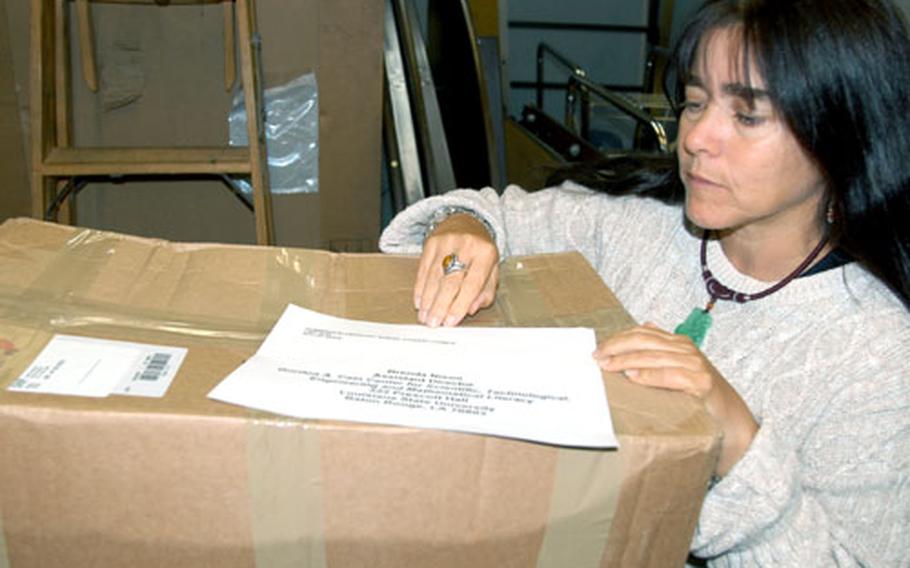 Edgren High School English teacher and senior class sponsor Laurie Kuntz gets boxes of donated shoes ready to mail to Louisiana. Cummings Elementary School donated the shoes to students displaced by hurricanes Katrina and Rita.