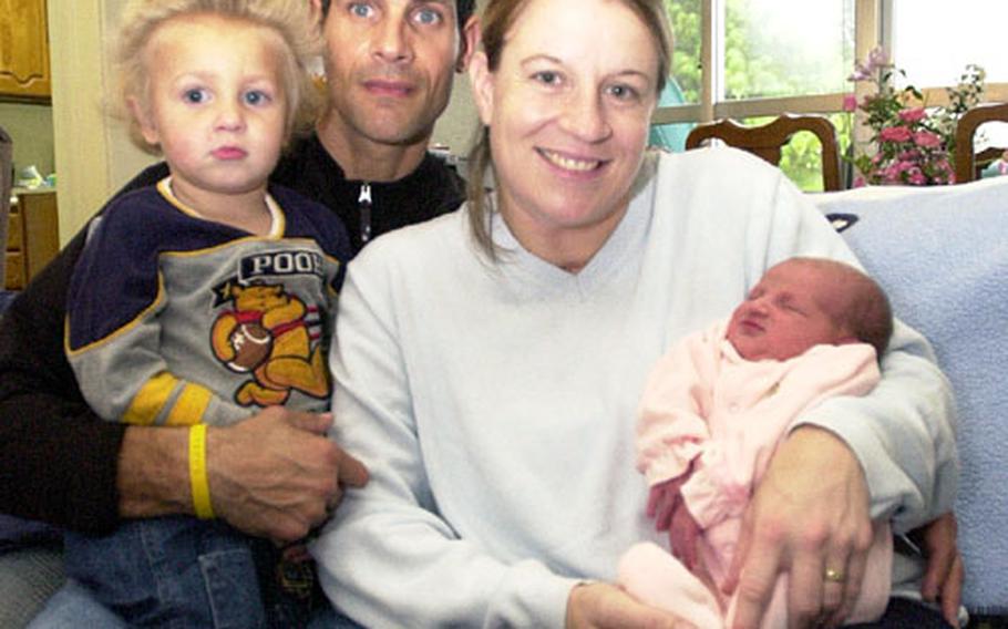 Army Maj. Christie Vaulx holds daughter Alison Cheyanne, the first baby born this year at a U.S. military hospital in the Pacific, on Thursday. Her husband, Army Master Sgt. Michael Vaulx, holds their 2-year-old son, Carson, in their home in Kishaba Housing on Camp Foster, Okinawa.