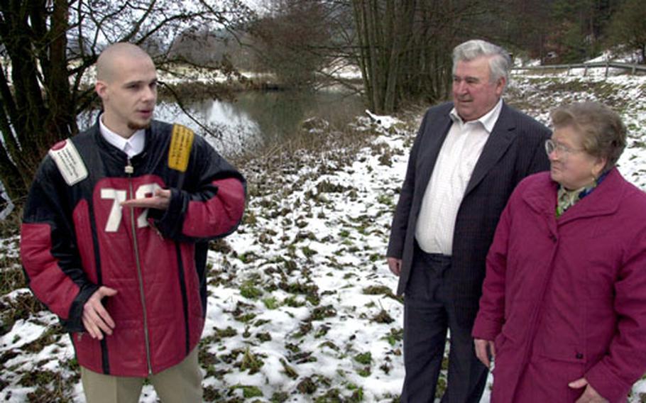 From left, Hohenfels Teen Center worker Ben Felton talks to Josef and Bernadette Heimler beside the Vils River on Friday. Felton rescued the pair after their car crashed into the river in May last year.