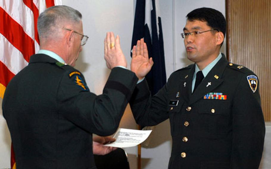Special Operations Command Korea commander Brig. Gen. Richard W. Mills, left, conducts a commissioning ceremony for Sgt. Eun-soo Kim, who was sworn is as a first lieutenant during a Dec. 28 ceremony at Yongsan Garrison, South Korea. Kim is now attending the Chaplain Officer Basic Course at Fort Jackson, S.C.