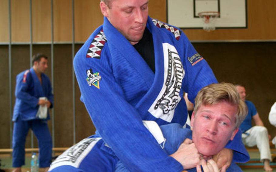 Army Staff Sgt. Micheal Czarnecki of Hohenfels applies a collar choke to Adam Pontnak of Heidelberg during a match in the absolute division of a submission fighting match on Sept. 3 in Garmisch, Germany.
