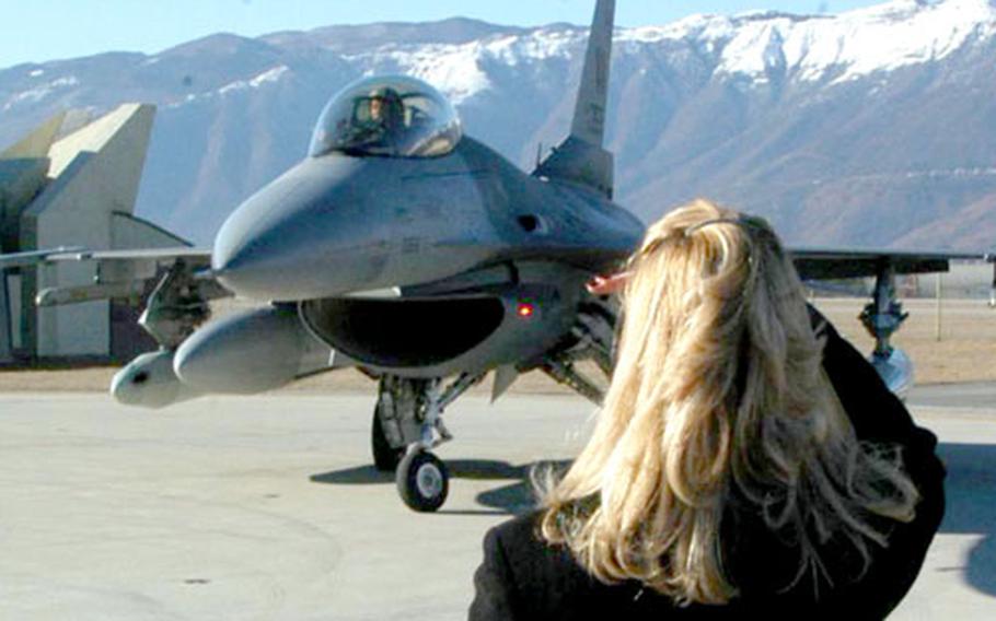Sara Trageser waits for her husband, Capt. Scott Trageser, to maneuver his F-16 into position Tuesday at Aviano Air Base, Italy. Six pilots from the 555th Fighter Squadron flew back to their home base after spending four months over the skies of Iraq.