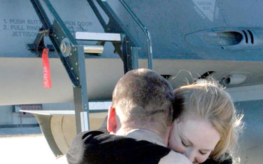 Capt. Scott Trageser embraces his wife, Sara, after climbing out of the F-16 he flew back to Aviano Air Base, Italy, on Tuesday.