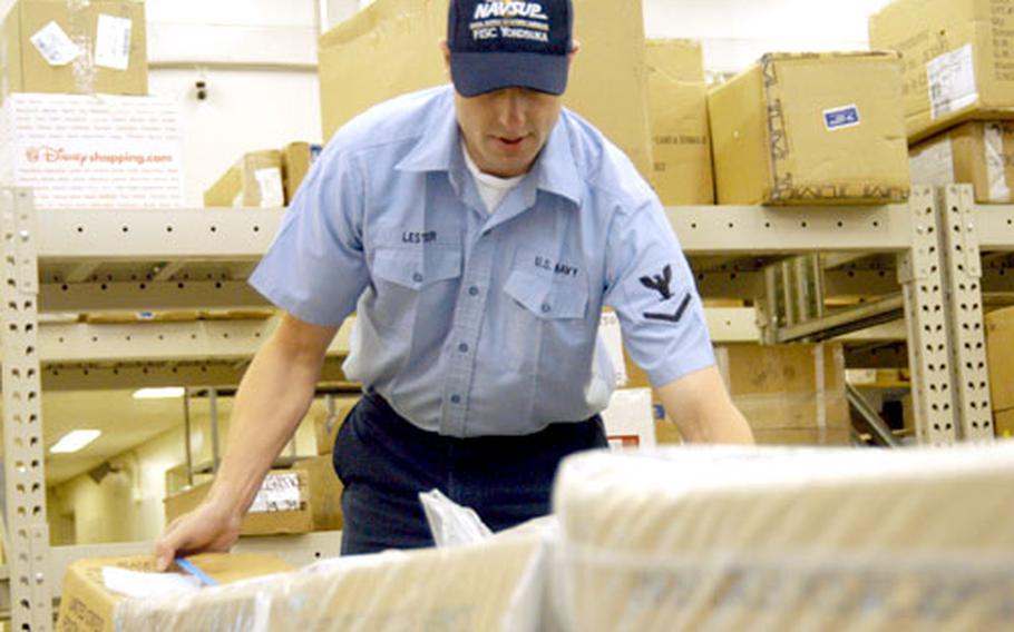 Petty Officer 3rd Class John Lester works the night shift at the Yokosuka Naval Base Post Office on Monday.