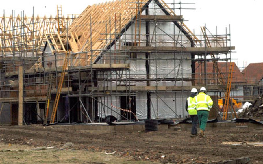 Construction workers walk past a home under construction adjacent to RAF Lakenheath. A lack of convenient housing options around the tri-base area has prompted the housing office to contract for 440 homes to be built right outside of RAF Mildenhall.