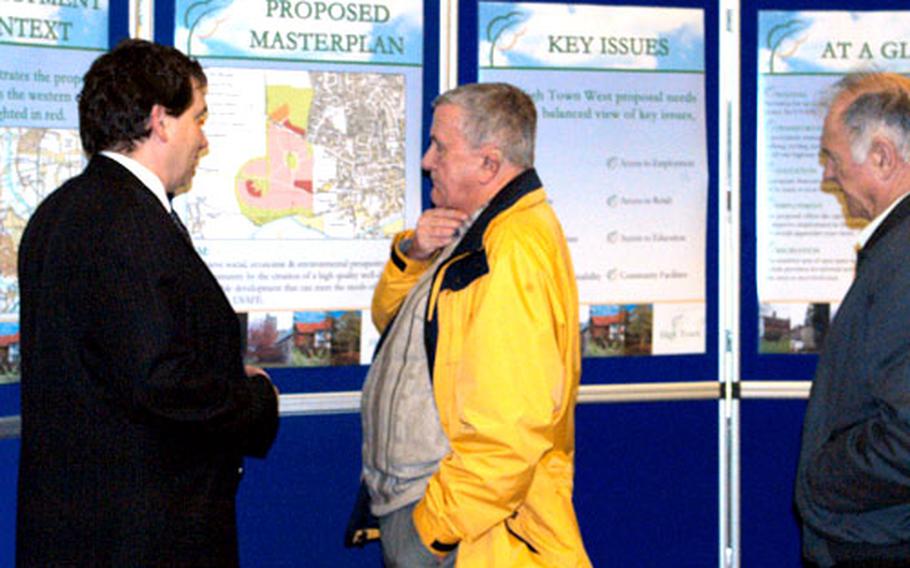 John Zeal listens as Ashwell Group representative Carl Atkinson describes the housing development plan. Widespread opposition to the plan has emerged from hundreds of people who live in and around the community.