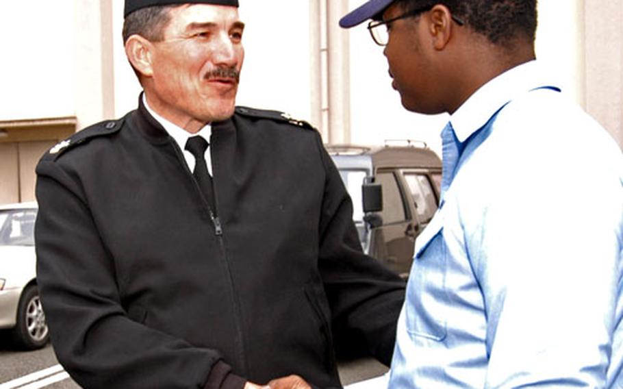 Master Chief Petty Officer of the Navy Terry Scott shakes hands with Seaman Apprentice Feordis Pearson, Jr., after the all-hands call at the Fleet Theater at Yokosuka Naval Base, Japan, on Tuesday.