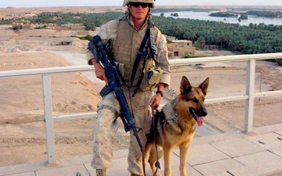 Dog handler Marine Sgt. Adam L. Cann stands with his dog Bruno in Iraq. Cann was killed in a suicide attack this month in Ramadi.