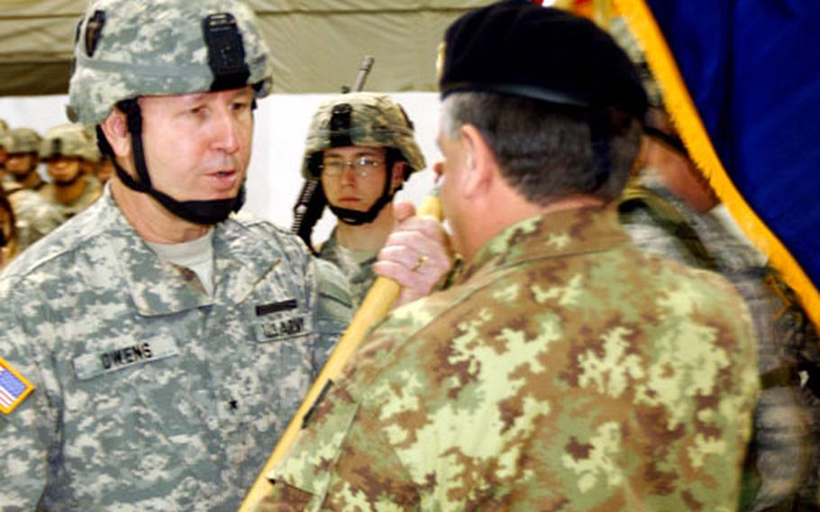 Brig. Gen. Darren Owens, commanding general of Task Force Falcon, 36th Infantry Division, Texas National Guard, and Kosovo Force Multi-National Brigade (East), passes the NATO guidon to Italian army Lt. Gen. Giuseppe Valotto, KFOR commander,during the transfer of authority ceremony Wednesday at Camp Bondsteel, Kosovo.