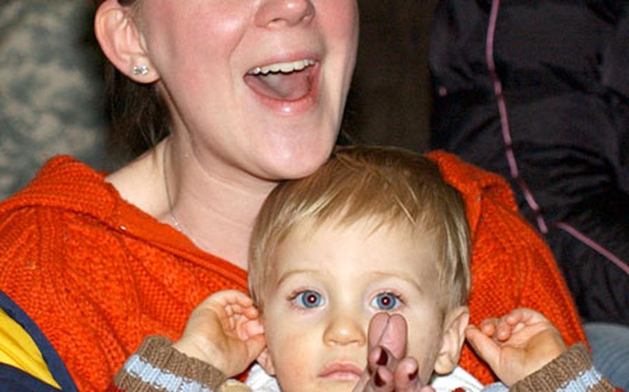 Cristina Zetterwall, holding son Justin, rejoices upon seeing her husband, Capt. Tim Zetterwall, 70th Transportation Company commander, return after serving nearly a year in Kuwait.