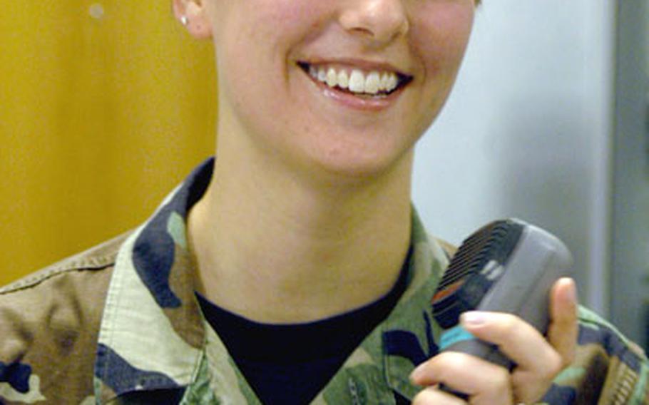 Airman 1st Class Krystal Williams holds the handheld radio of “the giant voice” at RAF Mildenhall’s command post. The public address system can make Williams as easy to understand as Ozzy shouting through a bullhorn.