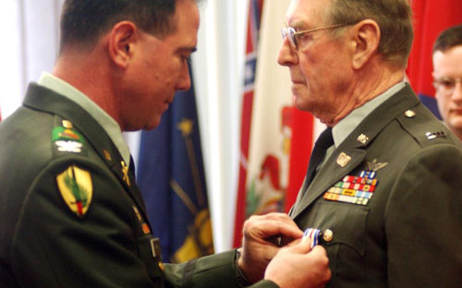 Col. Michael Ryan, assistant division commander for maneuvers for the 1st Armored Division, pins the Silver Star on retired Chief Warrant Officer 4 Walter Schramm during a ceremony at Fliegerhorst Casern in Hanau, Germany, on Tuesday. Schramm earned the Silver Star for gallantry in action on Feb. 17, 1966, flying a helicopter in the Bong Son mountains in Vietnam.