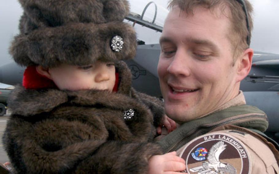 Capt. Christopher Thompson, an F-15E jet pilot with the 492nd Fighter Squadron, cradles his daughter, Allie, on RAF Lakenheath’s flight line on Wednesday.