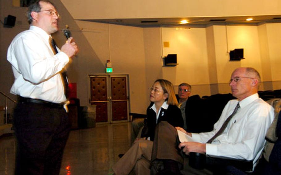 Gary Case, a specialist in asbestos and supervisor of the school’s asbestos cleanup, reports on the cleanup and on what precautions will be taken in future, at a town hall-type meeting about asbestos in the Yokota West Elementary School Media Center Wednesday night.