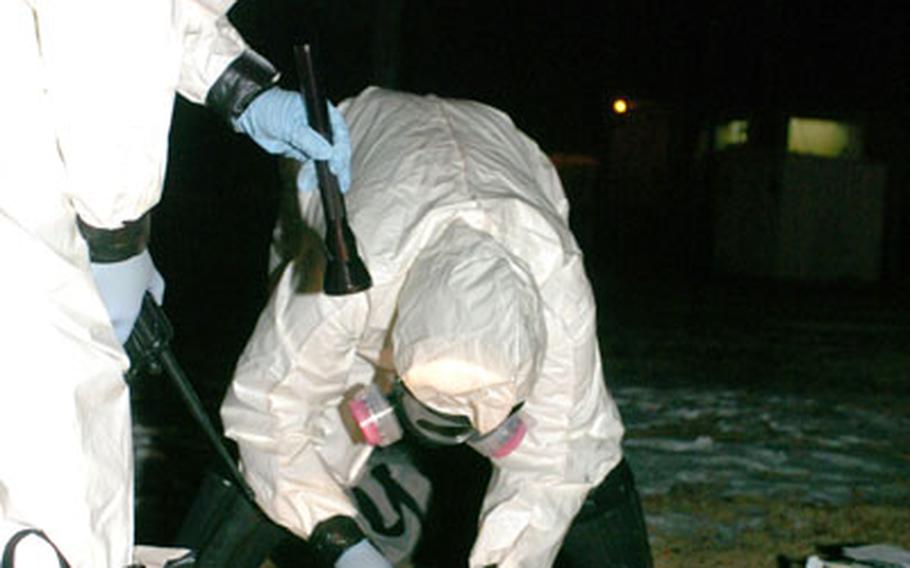 From left, bioenvironmental engineers Staff Sgt. Timothy Taylor and Senior Airman Toinette McGrew collect a sample of a white powdery substance Tuesday after a simulated accident scenario involving anthrax during Exercise Beverly Morning at Yokota Air Base, Japan.