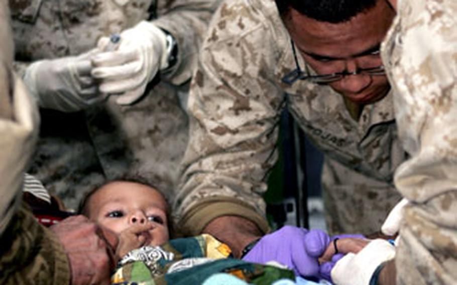 U.S. Navy doctors from Okinawa, currently with Combined Medical Relief Team 3 in Shinkiari, Pakistan, treat an 11-month-old girl recently in their hospital on Camp Wahlen. The girl was treated for pediatric sepsis, diarrhea and severe loss of appetite.