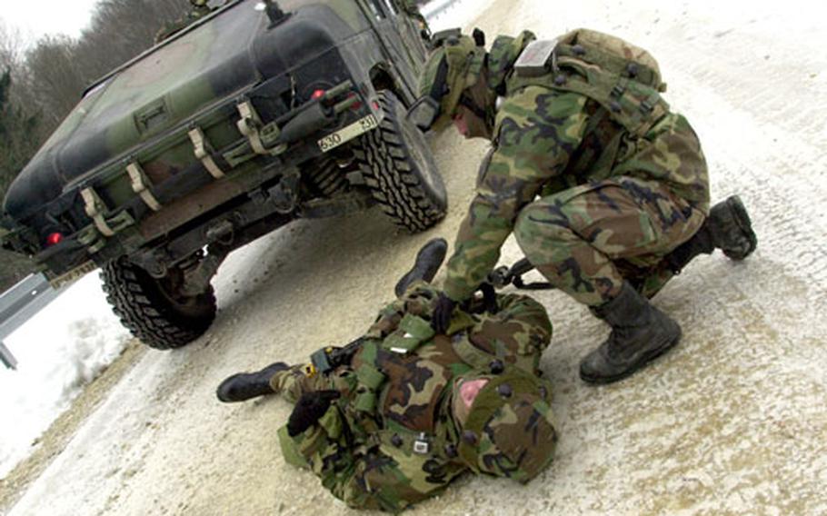 A 95th Military Police Battalion soldier renders aid to a comrade pretending to be wounded by a mock roadside bomb during a training session at the Joint Multinational Readiness Center at Hohenfels, Germany, on Wednesday.