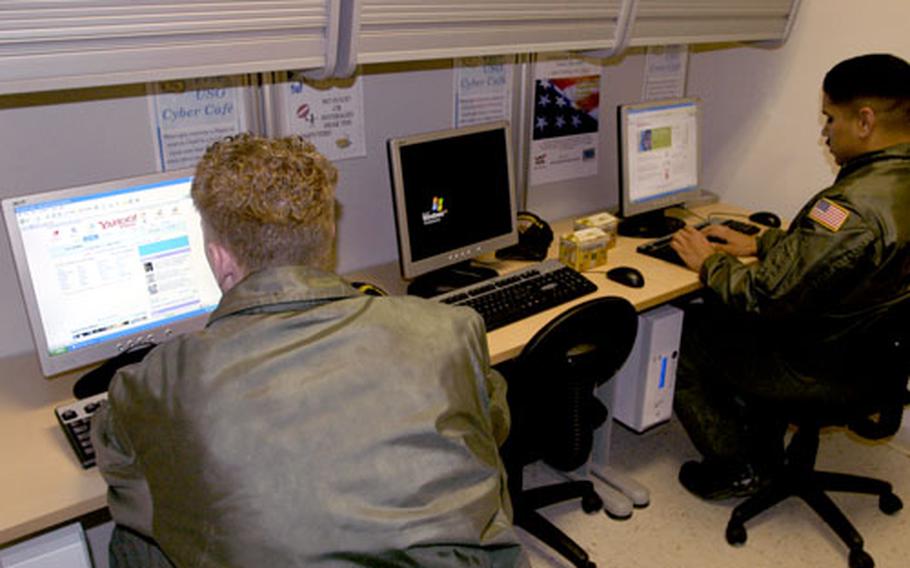 Airman Nicholas Ingram, left, and Airman Joseph Gonzales check their e-mail at the Naples air terminal USO Internet cafe. The new cafe offers five computers and wireless Internet for laptops.