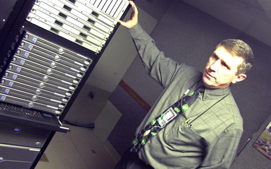 Dan Hoeh, director of instrumentation and simulations at the Joint Multinational Readiness Center in Hohenfels, Germany, stands with a stack of computers that are part of a new Exportable Instrumentation System that can be used to monitor and control training exercises anywhere in the world.