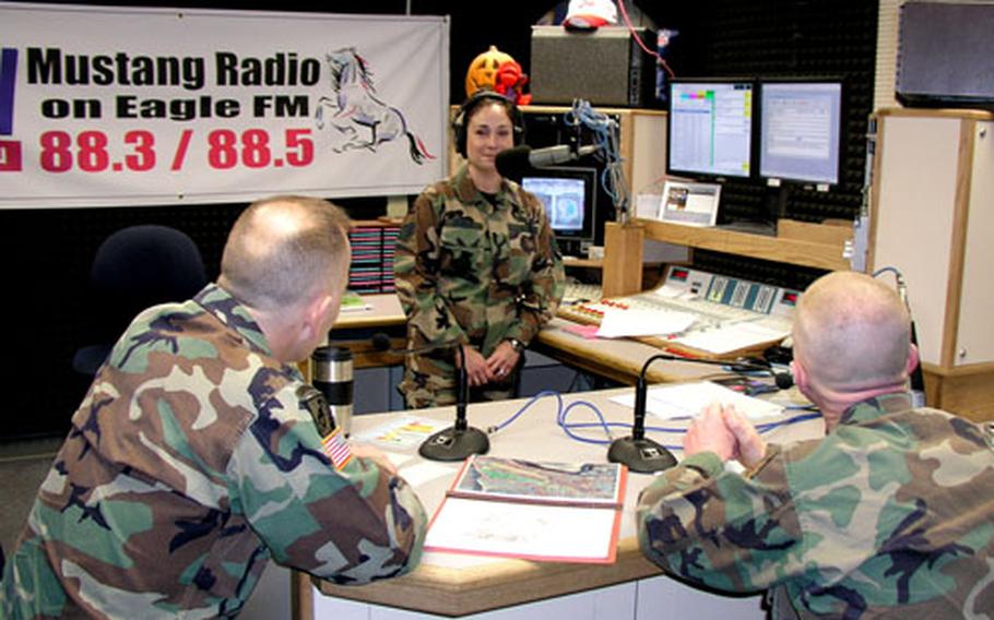 Camp Humphreys debuts its new weekly Area III radio show from the broadcast studios of AFN-Korea at Osan Air Base, featuring Area III commander Col. Michael J. Taliento, Jr., left, and Area III Command Sgt. Maj. Robert Frace, right. At the mike is Air Force Staff Sgt. Bronwyn Benito, sergeant-in-charge of radio operations.