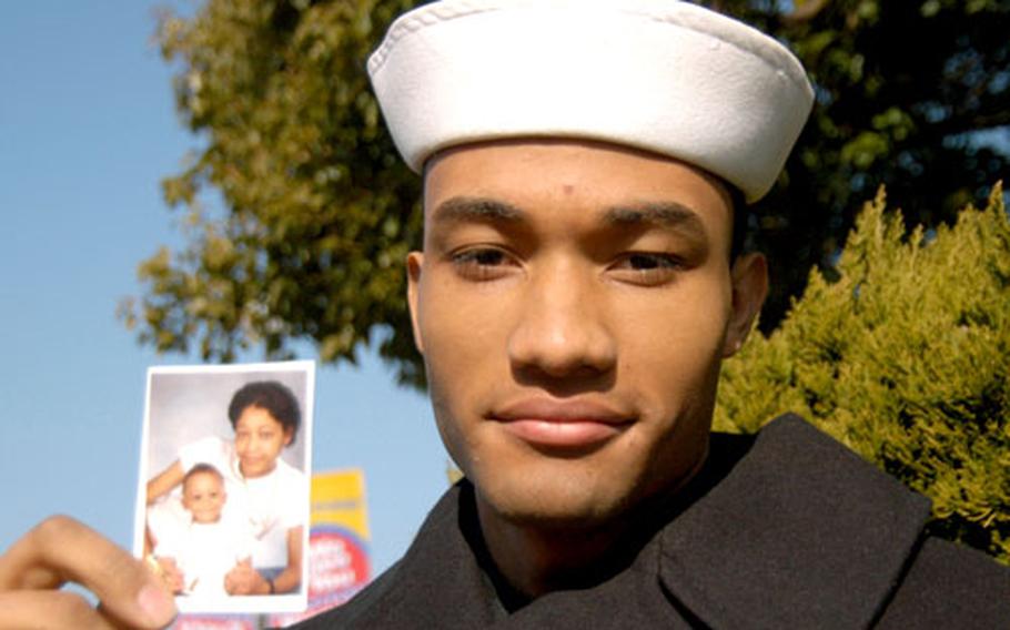 Naval Airman Timothy Dixon holds a picture of his sister Star and his nephew Marvin at Naval Air Facility Atsugi, Japan, last week. Dixon gave his sister a kidney in October.