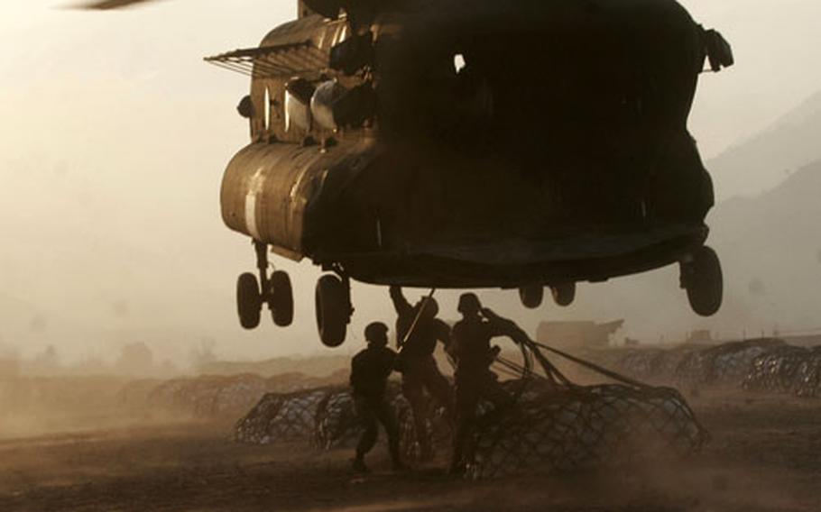 Marine landing support specialists attach external loads, or sling-loads, to the bottom of an Army CH-47 Chinook helicopter recently in Muzaffarabad, Pakistan. The Okinawa-based Marines currently are serving in Pakistan with Combined Medical Relief Team-3.