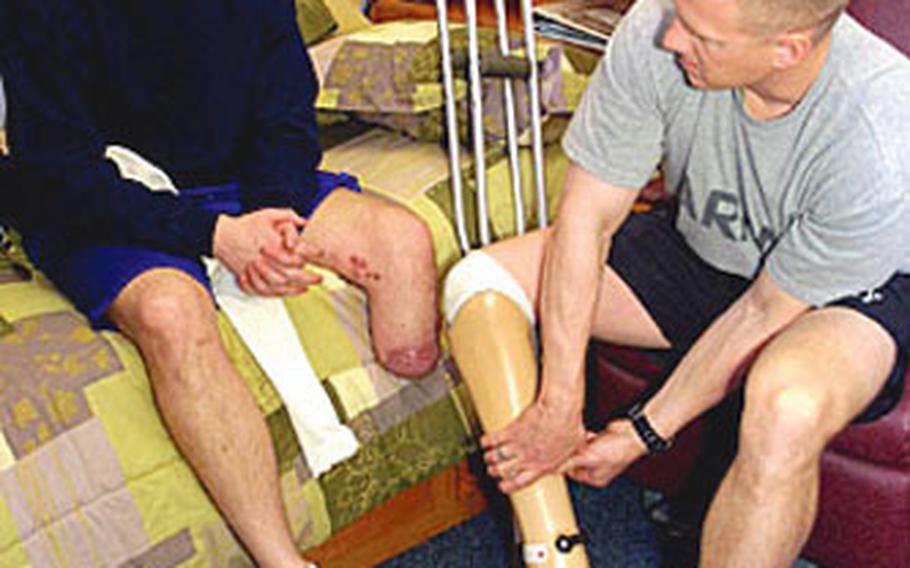 Capt. David Rozelle, right, talks about his prosthetic foot with Sgt. Justin Callahan at Walter Reed Army Medical Center in Washington. Rozelle recently told the Veterans Disability Benefits Commission that VA counselors should educate family members of wounded servicemembers about benefits and health care options.