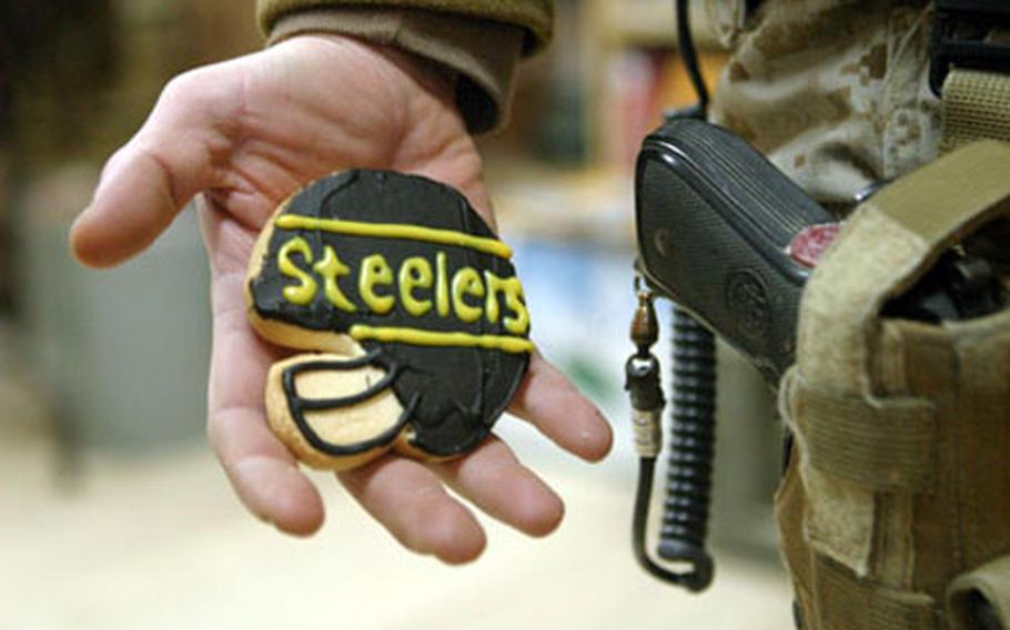 A Marine from Pennsylvania stationed at Camp Taqqadum stands with a “good luck cookie” that was sent from home to Iraq. Deployed troops and fans of the Pittsburgh Steelers and Seattle Seahawks hope their schedules will allow an opportunity to watch the Super Bowl.