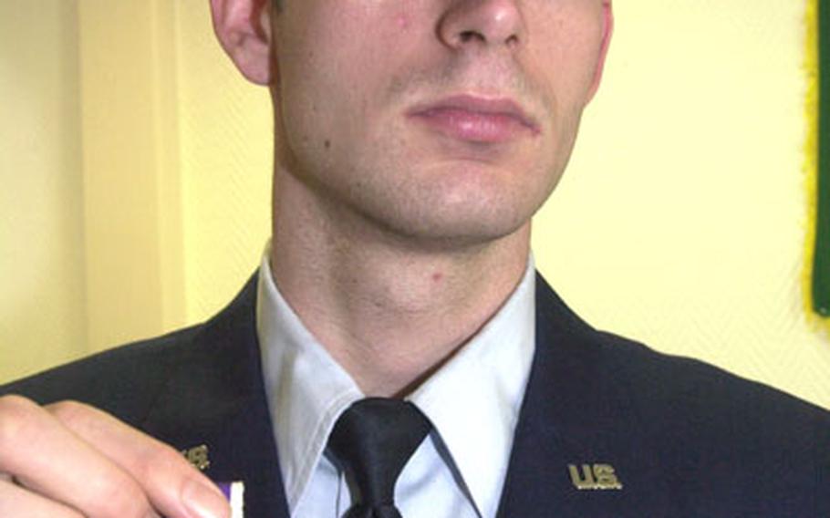Senior Airman Joseph Wilson holds the Purple Heart he recently received for injuries he sustained in Iraq last year. Wilson was manning the 50-caliber gun in an armored truck when an improvised explosive device detonated among the convoy.