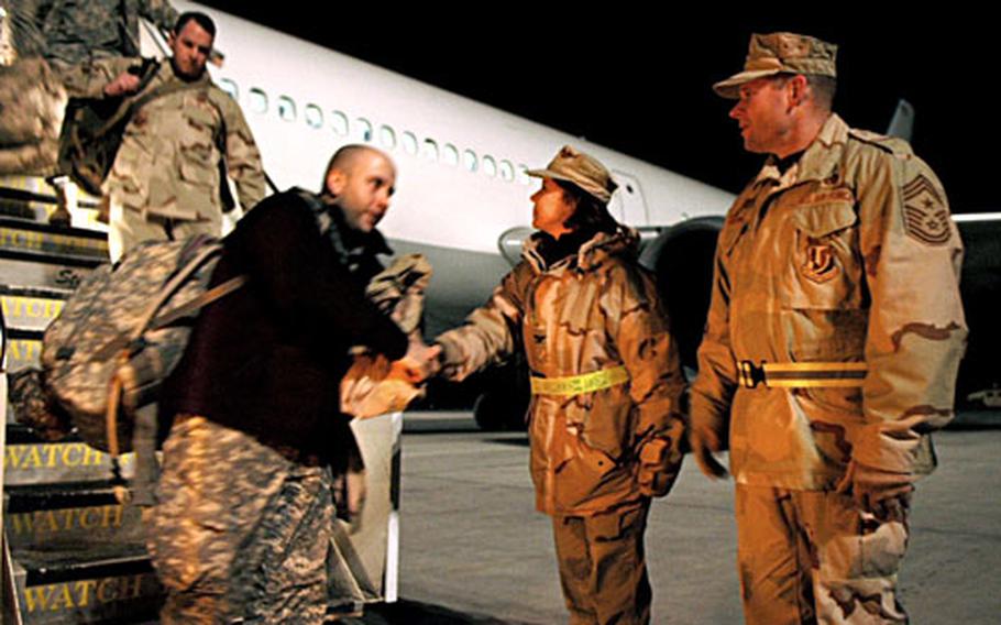 376th Air Expeditionary Wing vice commander Col. Pamela Milligan and Chief Master Sgt. Phillip Cherry hit the tarmac just before dawn to welcome incoming troops to Manas Air Base, Kyrgyzstan. Base officials make a point to personally greet large groups of troops transiting through Manas to Afghanistan.