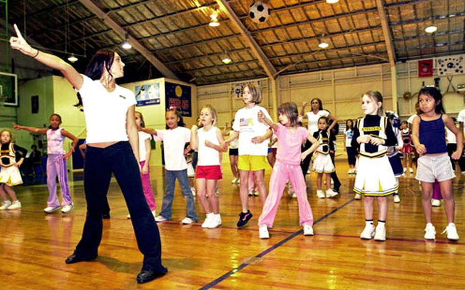 St. Louis Rams cheerleader Angeline O’Neal, left, leads young cheerleaders in dance moves during a clinic held Sunday at Kadena Air Base’s O’Connor Gym.