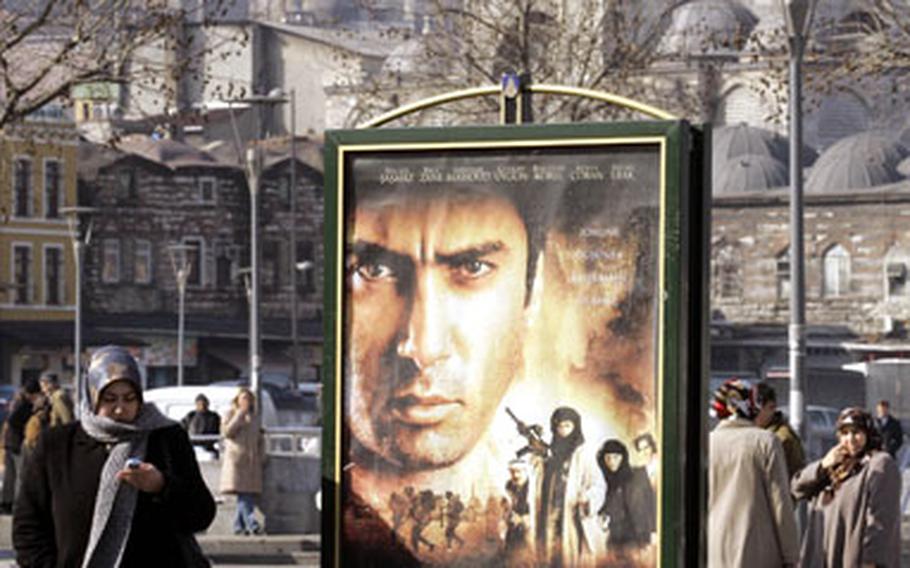 A woman stands next to a billboard featuring the new Turkish movie “Valley of the Wolves Iraq” in Istanbul, Turkey. Tickets for the movie, the latest of a genre of pop culture works feeding off growing anti-American sentiment in Turkey, are selling out across the country.
