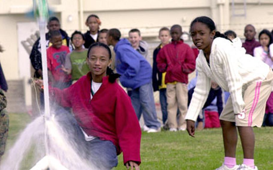 Kinser Elementary School fifth-graders Jasmine Vaughn, left, and Denise Jones watch as their water bottle rocket takes flight Tuesday.