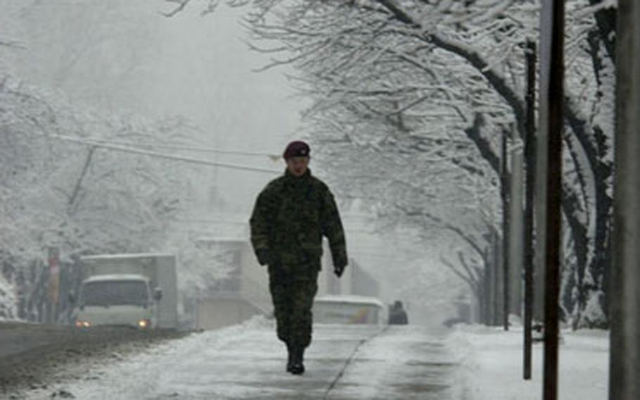 A soldier walks along the snowy I Corps Boulevard on Yongsan Garrison, South Korea, on Tuesday morning.