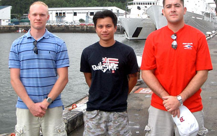 A machete attack victim in Singapore received emergency medical attention from these three men off the USNS John McDonnell. They are, from left, Merchant Mariner 3rd Mate Colin Campbell, U.S. Navy Petty Officer 2nd Class Paulryan Judi and Seaman Gregory Chaney.