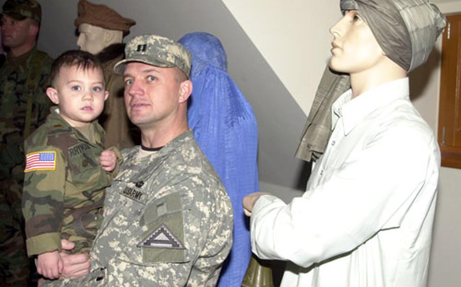 Capt. Charles Perryman, 39, and his son, Jackson, 3, listen to a briefing on suicide bombers, improvised explosive devices and car bombs at übensdorf’s military operations in urban terrain site on Wednesday.