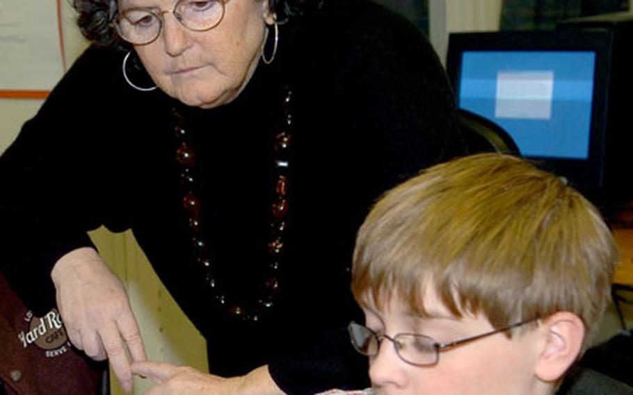 Ellen Minette, principal of Heidelberg Middle School in Germany, reviews work being done by seventh-grader Tommy Johnson in the school's library on Tuesday.
