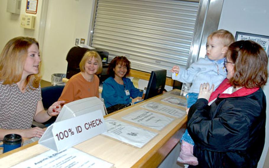 Staff Sgt. Therasa Carlson and her 23-month-old daughter, Evelynn, check in for a medical appointment last week at Misawa Air Base’s hospital, which recently was named the best Air Force overseas medical treatment facility for 2005.