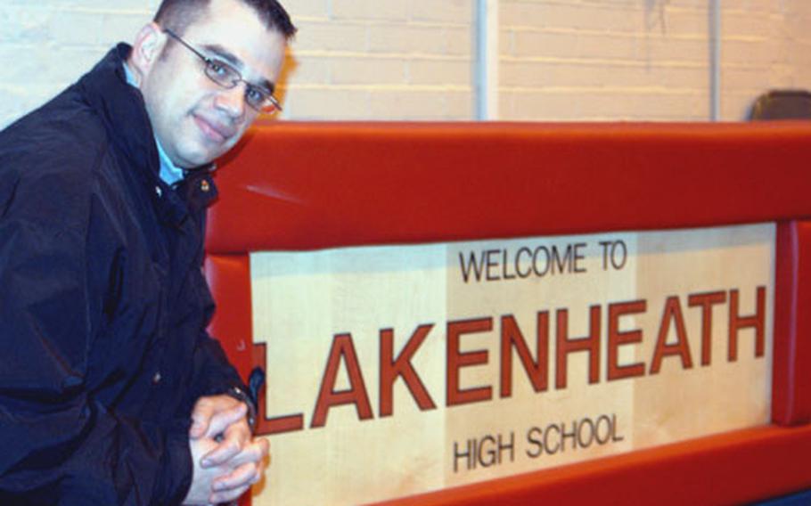 Staff Sgt. Michael Falvo kneels next to the scorer’s table at Lakenheath High School. After three years as the play-by-play announcer for the Lancers, Falvo is leaving to work for the American Forces Network in Portugal.