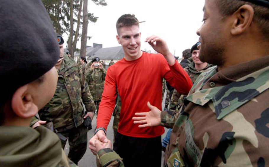 Spc. Jacob Truex is congratulated by friends and fellow GIs after he set a new record Tuesday in the five-kilometer backpack run at Fliegerhorst Casern in Hanau, Germany. Truex’s five-kilometer was 22 minutes, 20 seconds; he missed the mile record by about 10 seconds.