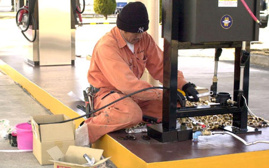 A Japanese contractor completes installation work at the old east-side gas station on Yokota Air Base, Japan. The Army and Air Force Exchange Service is preparing to reopen the facility as a second fuel option for base residents.