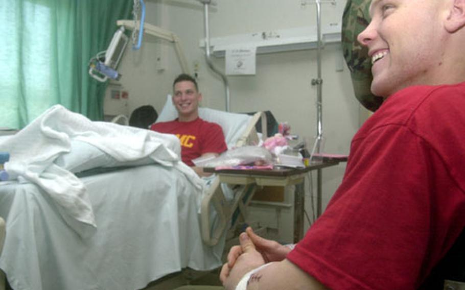 Marines Sgt. Chris Filley, right, and Lance Cpl. Russell Redhead discuss their injuries earlier this week at Landstuhl Regional Medical Center in Germany. The Marines were wounded in the same roadside bomb explosion Feb. 10 near Hit, Iraq.