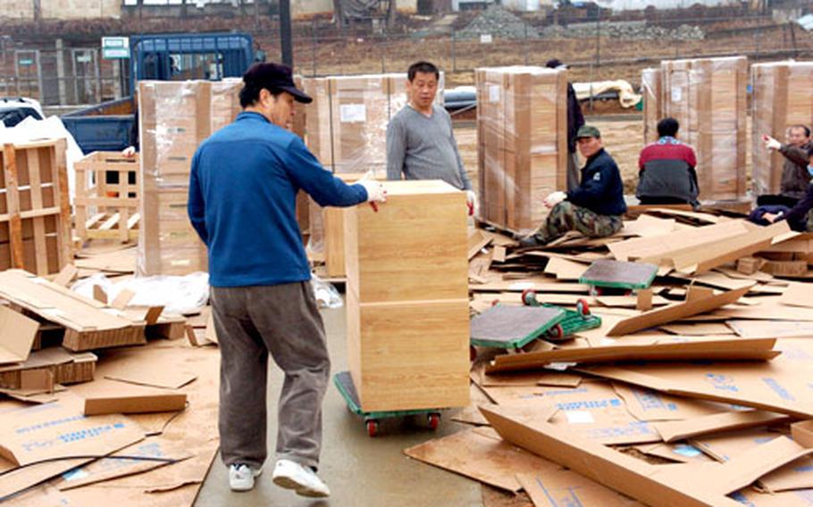At Camp Humphreys in Pyeongtaek, South Korea, earlier this week, workers unload furniture that will go into barracks at the newly built twin six-story barracks-dining hall complex in the post’s Zoeckler Station area.