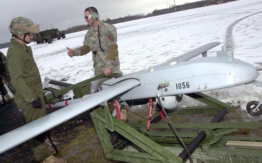 Spc. Robert Hartung, left, and Cpl. Jonathan Williams, both of Company C, 101st Military Intelligence Battalion, roll a Shadow Unmanned Aerial Vehicle onto its launch ramp at Vilseck Forward Arming and Refueling Point on Thursday.